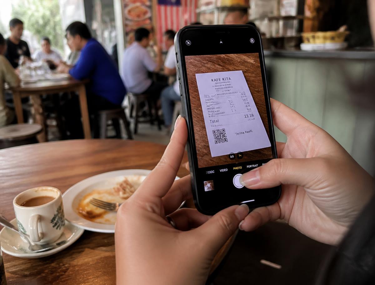 Owner photographing paper receipt
